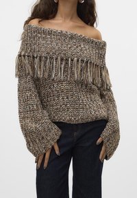 Dzianinowy sweter odkrywający ramiona w wielu odcieniach brązu, z frędzlami u dołu i szerokimi rękawami, o luźnym splocie nadającym strukturę.