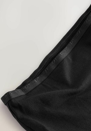 Svarta leggings med en slät textur, elastisk midja med diskret branding och en åtsittande design.