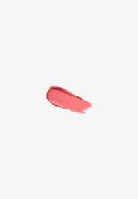 Smooth, curved swatch of matte coral-pink lipstick on a white background, showing texture and color consistency.