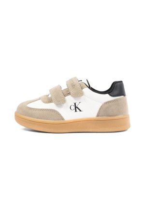 Niski sneaker z beżowego zamszu, białej skóry, czarnym kołnierzem, beżowymi podwójnymi paskami na rzep, gumową podeszwą i czarnym logo "cK" z boku.