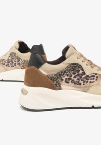 Baskets beiges et brunes avec des accents de motif léopard, des détails en suède et paillettes, un support de talon noir, et une épaisse semelle blanche.