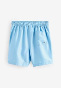 Pantaloni da bagno azzurri chiari con elastico in vita, texture liscia e una tasca posteriore con un piccolo dettaglio a occhiello.