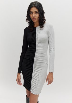 Robe à manches longues avec un design déstructuré en tissu froncé noir et gris, mettant en valeur une silhouette ajustée et des textures contrastées.