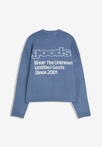 Blauwe gebreide trui met witte tekst op de achterkant die zegt "goods" en "Wear The Unknown Untitled Goods Since 2001," lange mouwen, ribbelmanchetten en -zoom.