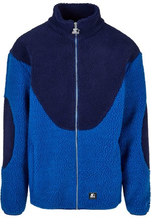 Blue and navy fleece jacket with a high collar, full front zipper, and textured fabric. Features contrasting large panels and a branded patch.