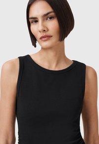 Top senza maniche nero con scollatura rotonda, realizzato in un tessuto liscio. Presenta dettagli arricciati sui lati, offrendo un look aderente.