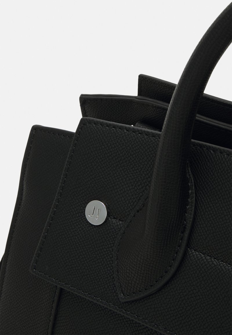 Schwarze Lederhandtasche mit strukturierten Oberflächen, ausgestattet mit zwei Griffen und einem metallischen Logo-Accent auf der vorderen Klappe.