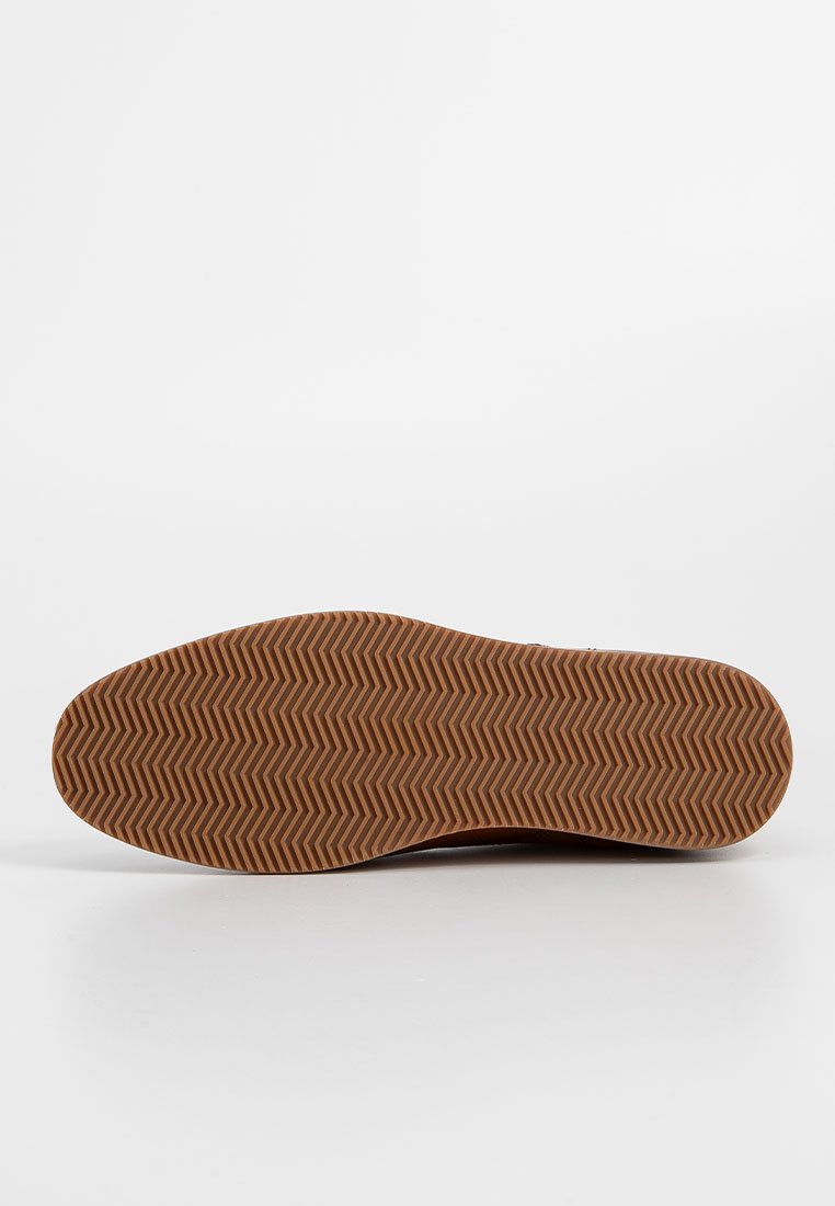 Braune Gummisohle mit einem strukturierten Fischgrätmuster. Glatte Kanten und abgerundete Ferse, entworfen für Traktion und Langlebigkeit.