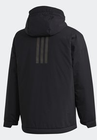Veste noire à capuche avec manches longues et trois bandes réfléchissantes verticales sur le haut du dos.