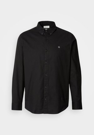 Black button-up shirt made from cotton with a classic collar, long sleeves, and a small CK logo on the left chest.