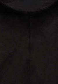 Close-up of black suede fabric with visible central seam stitching and subtle texture variations.