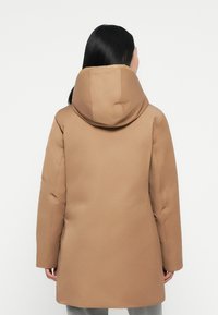 Bruine donzen jas met een grote, gestructureerde capuchon. Heeft een gladde, matte textuur en lange mouwen, ontworpen voor warmte en comfort.