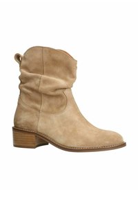 Stivaletto in suede beige con un design morbido, punta arrotondata e tacco in legno impilato. Presenta cuciture visibili e un cappio per tirare.