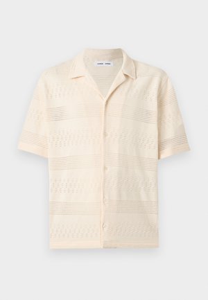 Μπλούζα από κρεμ πλεκτό ύφασμα με κοντά μανίκια, διακοσμητικά σχέδια με ανοιχτή πλέξη, γιακά τύπου καμπ και κουμπιά στο μπροστινό μέρος.
