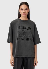 T-shirt grigia oversize realizzata in morbido tessuto, con stampa grafica nera, scollatura rotonda e maniche corte.