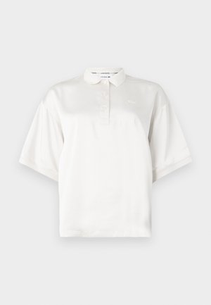 Biela polo košeľa s krátkym rukávom vyrobená z hladkej tkaniny, s prednou légiou s tromi gombíkmi a vyšitým logom na ľavej hrudi.