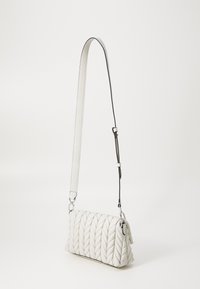 Borsa trapuntata bianca con texture intrecciata, dotata di tracolla staccabile bianca e nera e hardware argentato.