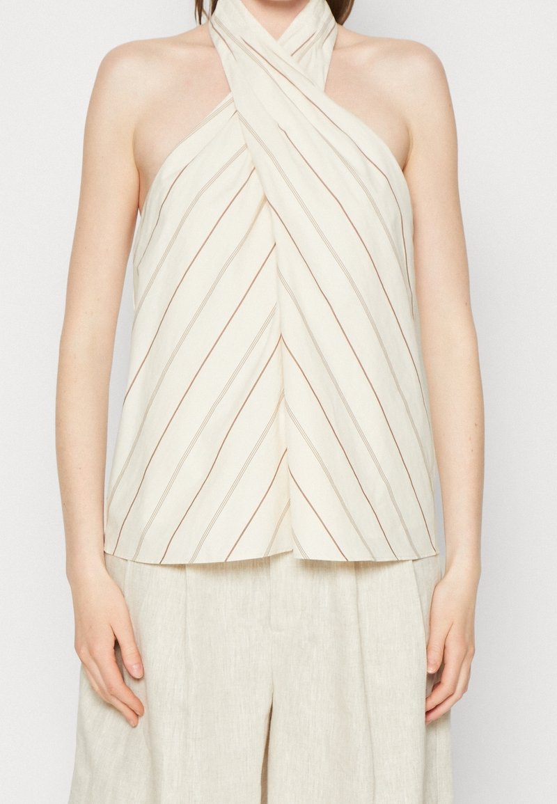 Halenka za krk z lehkého krémového materiálu s diagonálními hnědými pruhy. Disponuje překrytým designem a uvolněným střihem.