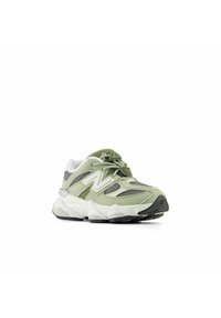Ljusgröna sportskor med mesh- och mockadesign, tjock vit och grå sula samt reflekterande detaljer och tydlig branding.