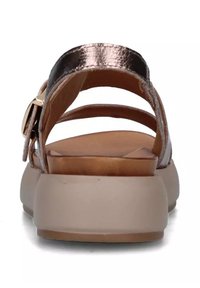 Sandali metallici bronze con più cinturini, una soletta marrone liscia e una suola beige spessa. Presentano un dettaglio con fibbia dorata.