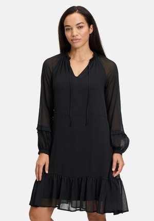 Robe noire avec des manches longues transparentes, un décolleté en V, un détail à cordon de serrage et un ourlet froncé. Tissu doux et léger avec une silhouette fluide.