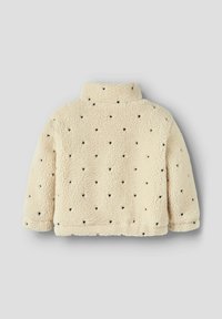 Veste en polaire crème à col montant, ornée de petits motifs en forme de cœur noir. Texture douce et coupe ajustée.