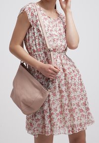 Šaty s květinovým potiskem, krátkými volánkovými rukávy, páskem v pase a světlým pozadím. Světle růžová kožená crossbody taška s nastavovatelným popruhem.