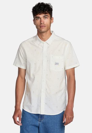 Short-sleeve button-up shirt in white fabric with a subtle print of small palm trees and flowers, featuring a chest pocket and embroidered label.