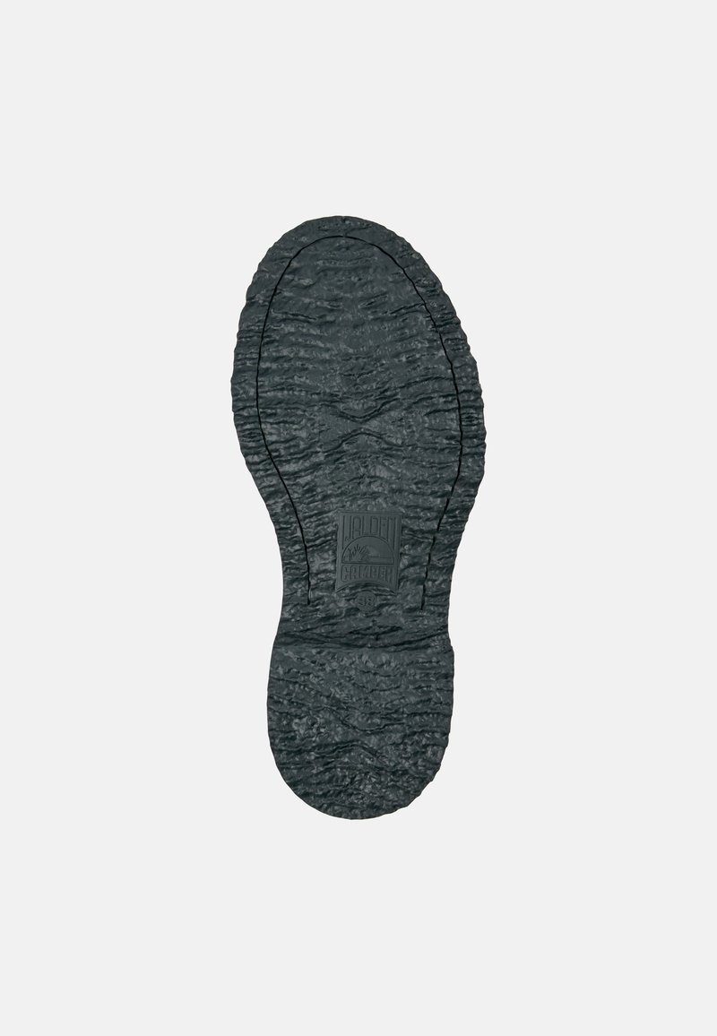 Semelle de chaussure en caoutchouc noir avec surface texturée, comprenant des stries, des rainures et une empreinte de logo. Forme globale ovale avec un bord renforcé.