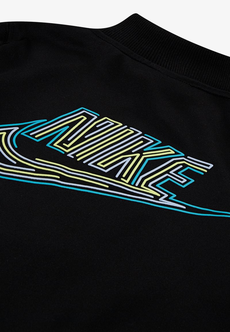 Sudadera negra con un logo de Nike multicolor en azul, amarillo y blanco, con líneas gruesas y una superficie texturizada.