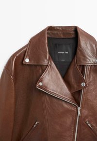 Braune Leder-Motorradjacke mit Reverskragen, silbernem Beschlag, asymmetrischem Reißverschluss und zwei Reißverschlusstaschen.