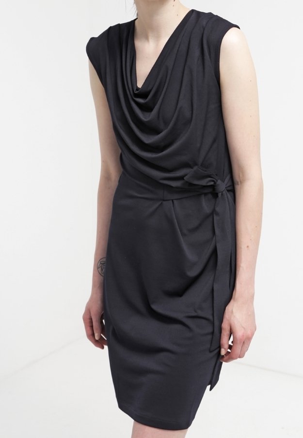 Robe noire drapée à manches courtes, col froncé et détail noué sur le côté, fabriquée en tissu lisse. Silhouette ajustée avec ourlet à hauteur du genou.