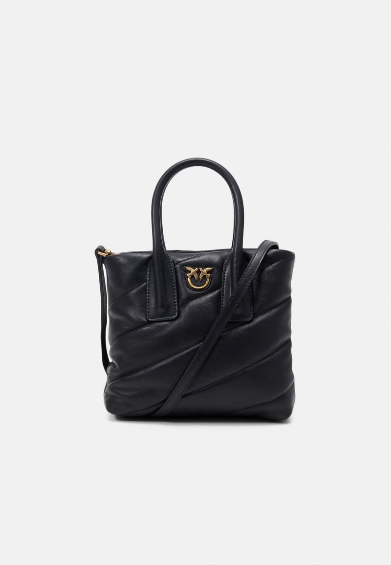 Sac à main en cuir noir avec deux poignées, un motif matelassé diagonal, un emblème logo doré et une longue bandoulière réglable.