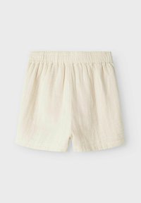 Shorts en lin couleur écrue avec une taille élastique, affichant une coupe décontractée et une texture douce, adaptés pour un usage décontracté.