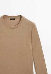 Pull beige à manches longues col rond en tissu fin tricoté, présenté à plat sur fond blanc.
