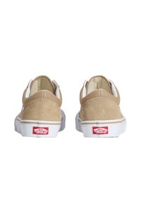 Baskets en daim tan avec accents blancs et semelles en caoutchouc. À l'arrière, l'étiquette de logo rouge et les détails de couture. Design classique bas.
