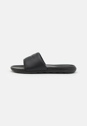 Black slide sandal with a smooth synthetic strap and textured footbed. Features a slight arch and rubber sole with tread for grip.