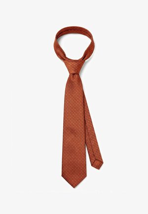 Ruostevärinen solmio, jossa on hienovarainen vinoraitakuvio ja pieniä valkoisia täppäkoristeita, solmittu klassiseen solmuun valkoisella taustalla.