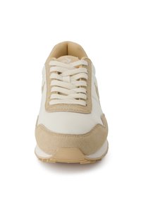 Sneaker beige e bianca con una finitura in pelle liscia e suede, caratterizzata da una punta rotonda, lacci piatti e suola in gomma con grip.