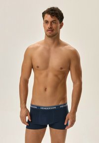 Granatowe bokserki wykonane z elastycznego materiału, z szerokim elastycznym pasem w jasnoszare logo 'HENDERSON'. Gładka tekstura.