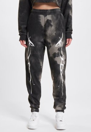 Joggebukser i sort og grå tie-dye mønster, med hvitt abstrakt design på sidene, elastisk liv, og ribbede ankler.