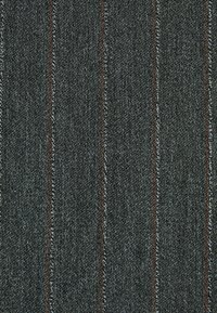 Dunkelblauer Denim-Stoff mit vertikalen Ripplinien in Grau und kontrastierenden roten Nähten, mit einer strukturierten Oberfläche und dezentem Glanz.
