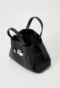 Borsa a mano in pelle nera con due manici, superficie texture, scomparti interni e dettagli in metallo argentato. Design a bocca aperta.
