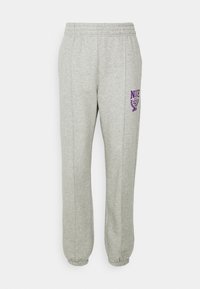 Grå mjukisbyxor med elastisk midja, avsmalnande ben och en lila Nike-logotyp på vänster lår. Mjukt material av bomullsblandning.