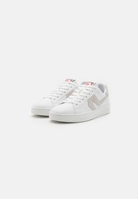 Hvide lædersneakers med en struktureret beige ruskindaccent, flade snørebånd, polstret krave og en hvid gummisål. Rød og sort logo p�å tungen.