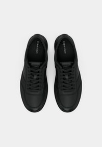 Black leather sneakers with textured finish, flat laces, padded collar, and subtle contrasting blue accents along the sole.