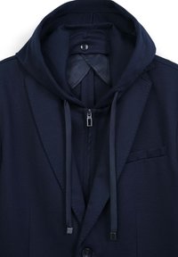 Blazer blu navy con cappuccio integrato, caratterizzato da una chiusura con zip e cordini. Tessuto liscio e dettagli di cucitura discreti sui revers.