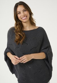 Poncho de punto en gris oscuro con un ajuste holgado, que presenta un patrón de olas texturizado y mangas amplias. Material suave con detalles de tejido abierto.