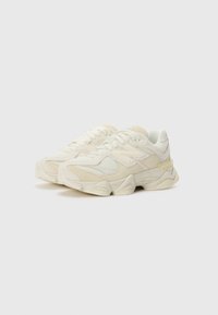 Sneakers i off-white mesh og ruskindsmaterialer med en klodset sål og teksturerede detaljer. Har snørebåndslukning og diskret branding.