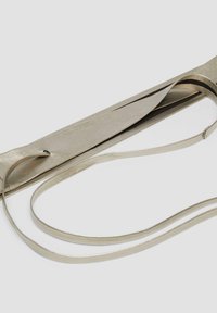 Metaalachtige zilveren riem met een elegante, gestructureerde afwerking, met een smalle band en lusdetail voor een veilige sluiting.